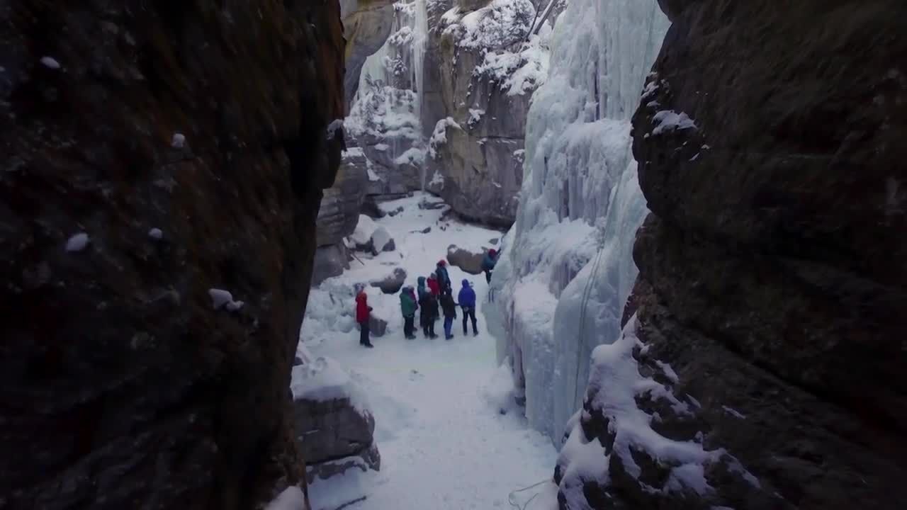 在冰峡谷中创造路的登山者视频特效