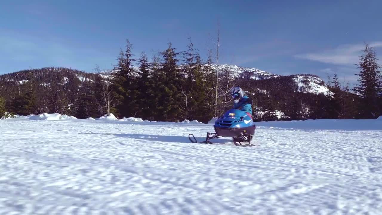 孩子骑雪地摩托穿越冰雪覆盖的田野