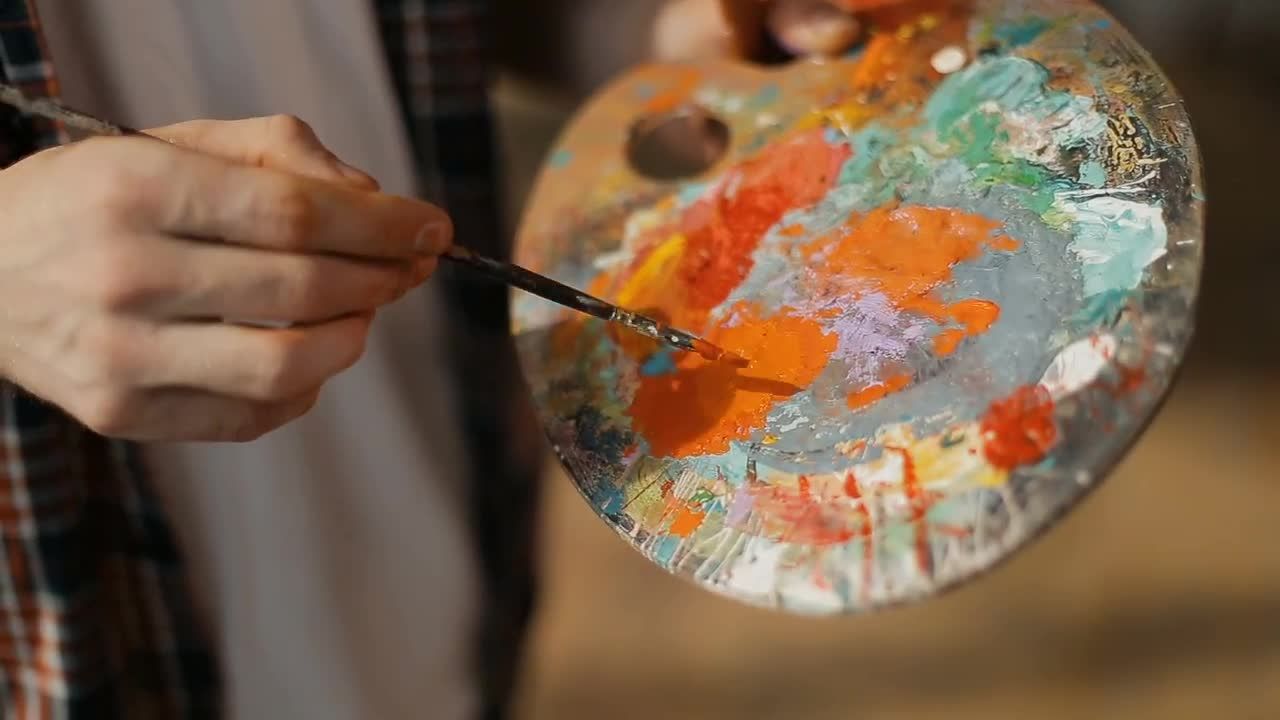 处理调色板上的油漆的画家实拍视频素材