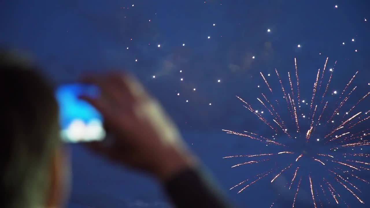 一个人举着手机拍摄烟火表演视频素材