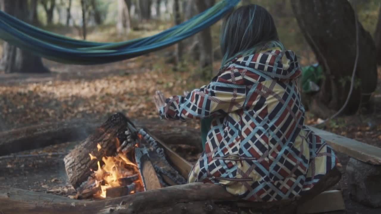 一个女人伸出双手在篝火上取暖视频素材