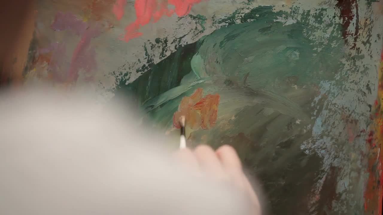 使用油画颜料在画布上绘画的艺术家的视频