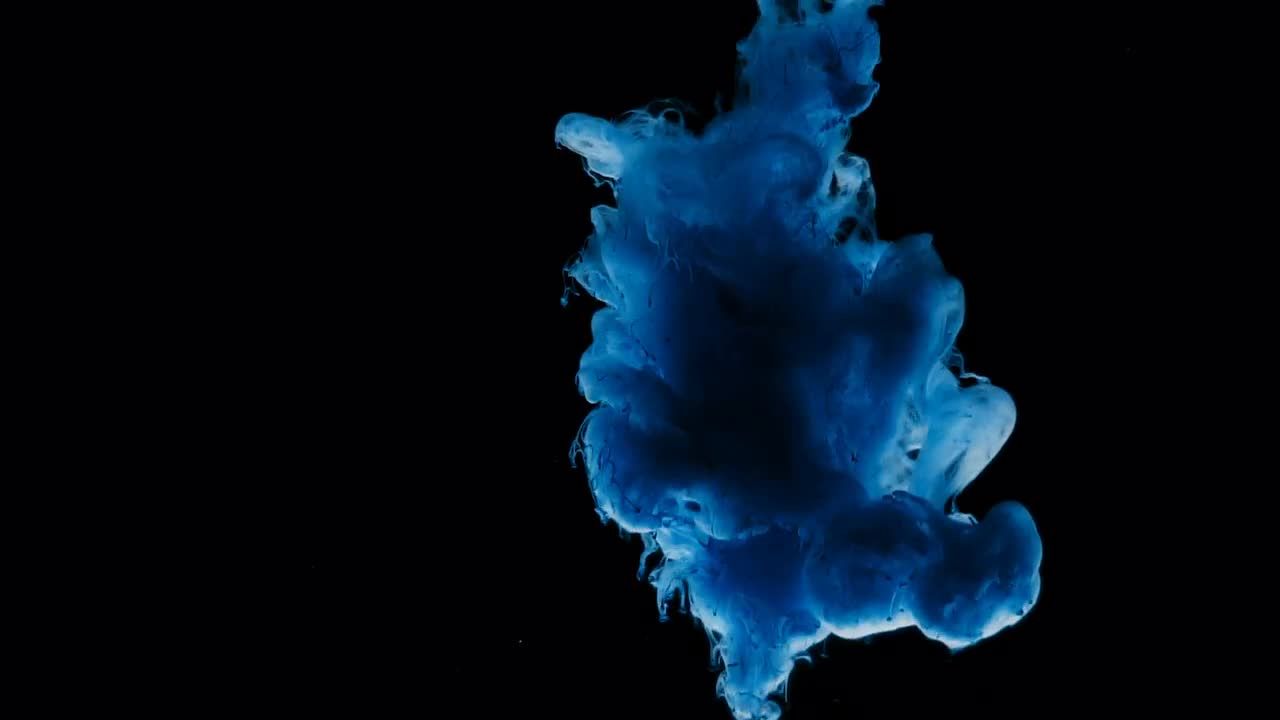 蓝色油漆泼洒在黑色背景视频素材