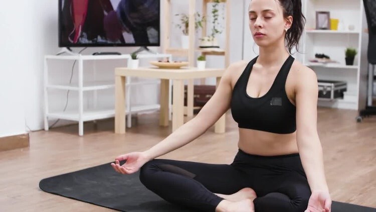 观看在线瑜伽视频并练习的女人视频素材