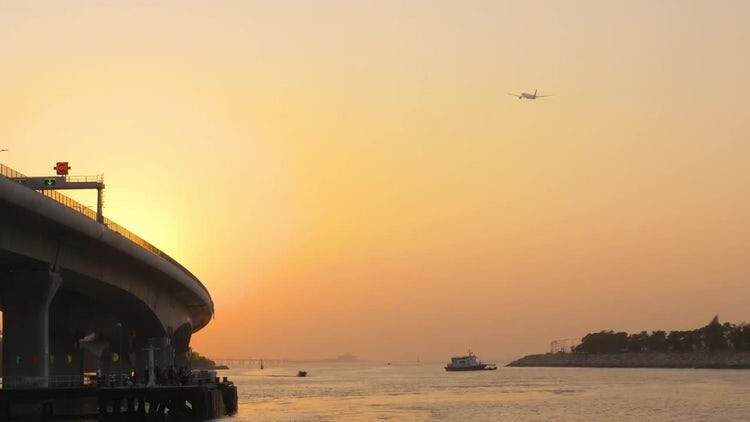夕阳下香港机场附近的大桥旁飞机在起飞视频素材