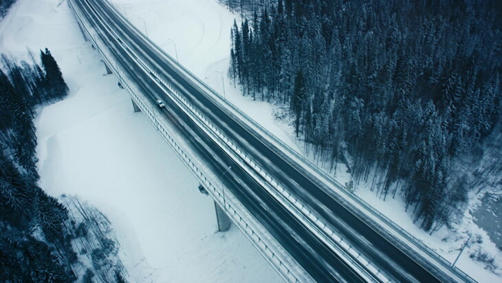 卡车沿着白雪皑皑的丛林上方的高速公路上行驶