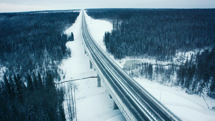 空中视角充满积雪的森林中的公路