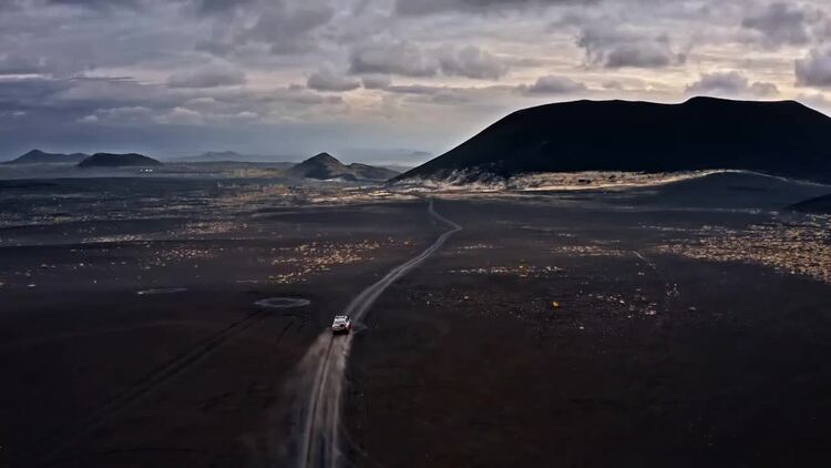 驾驶吉普车在火山陆地天际线实拍视频