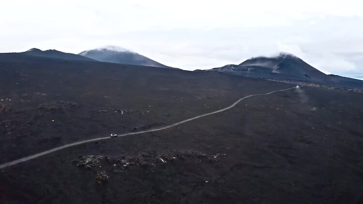吉普车在火山土地上向山中行驶实拍视频